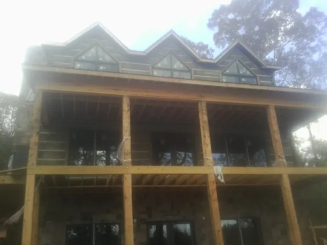 Dormers and porch framing on a large log home under construction — Roof Coating work by our crew in Ellwood City